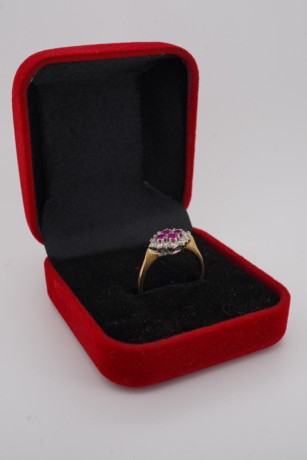 A ruby and diamond ring, designed as a lozenge-shaped cluster, set with four circular-cut rubies within a border of circular-cut diamonds, mounted in 18ct gold, size O, British hallmarks, gross weight 3 grams, Condition: